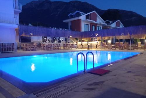 ein Pool in der Nacht mit blauen Lichtern in der Unterkunft Hotel NilSu in Oludeniz