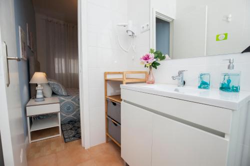 Baño blanco con lavabo y espejo en Terrace Matosinhos House, en Matosinhos