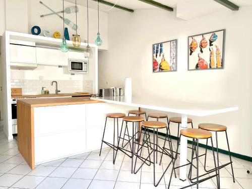 une cuisine avec des placards blancs et des tabourets de bar dans l'établissement COUP DE CŒUR - ILE DE RE - Maison 3 chambres, à Rivedoux-Plage
