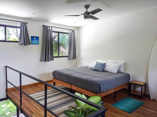 a bedroom with a bed with a ceiling fan at El Hábita CASA MAR in Santa Teresa Beach