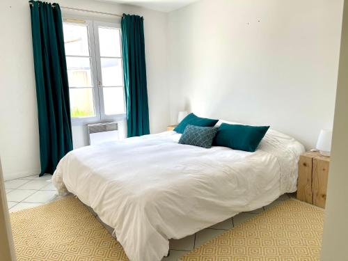 1 dormitorio con 1 cama blanca grande con almohadas azules en COUP DE CŒUR - ILE DE RE - Maison 3 chambres en Rivedoux-Plage