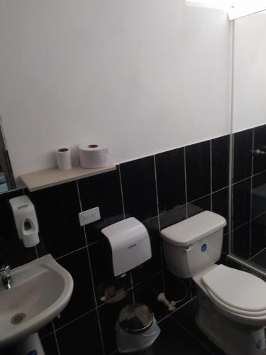 a bathroom with a toilet and a sink at Hotel Aura Medellin in Medellín