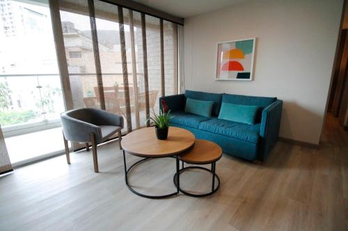 a living room with a blue couch and a table at Estelar Apartamentos Medellin in Medellín