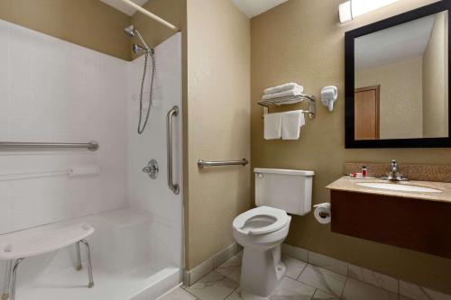 a bathroom with a toilet and a sink and a mirror at Super 8 by Wyndham Sikeston/Miner Area in Sikeston
