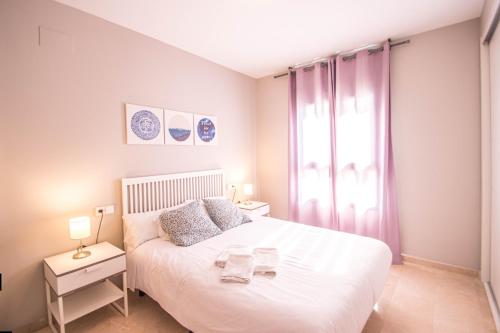 a bedroom with a white bed and a window at Recogidas Apartment 23 in Granada