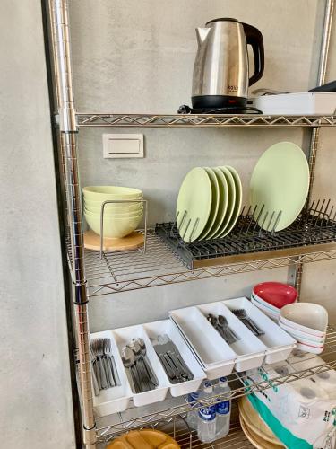 a kitchen with plates and utensils on a shelf at 高雄好日子914包棟KTv民宿 in Kaohsiung