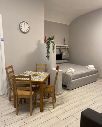 Pokój ze stołem i krzesłami oraz sypialnią w obiekcie Ropellì Santa Chiara w mieście Neapol