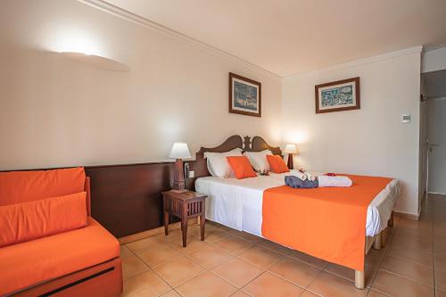 una camera d'albergo con due letti e un divano di Le Maracuja a Sainte-Anne