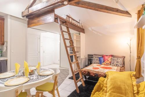 a room with a loft bed and a table and chairs at La Petite Reine Blanche in Dammarie-lès-Lys