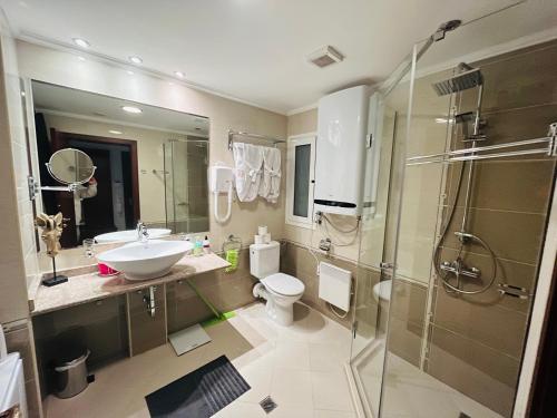 a bathroom with a sink and a toilet and a shower at Luxury Downtown Apartment - Gondola in Bansko