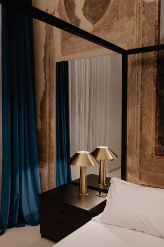 a bedroom with a bed with two lamps on a dresser at Casa Conoscenti Suites in Bologna
