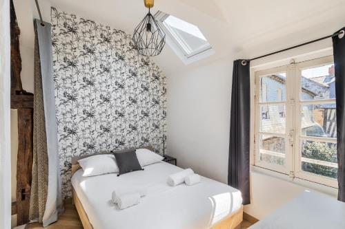 une chambre avec un lit blanc et une fenêtre dans l'établissement LE PETIT MARIUS - Cocon au cœur du centre-ville historique, à Rennes