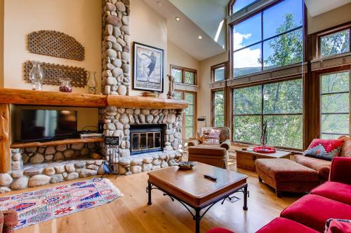 a living room with a large stone fireplace at Highlands Area by East West Hospitality in Beaver Creek