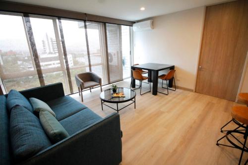 a living room with a blue couch and a table at Estelar Apartamentos Medellin in Medellín