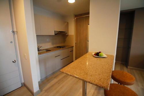 a kitchen with a table with a bowl of fruit on it at Estelar Apartamentos Medellin in Medellín