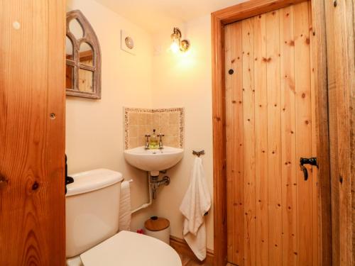 un baño con inodoro y lavabo en Bent Chapel Cottage, en Matlock