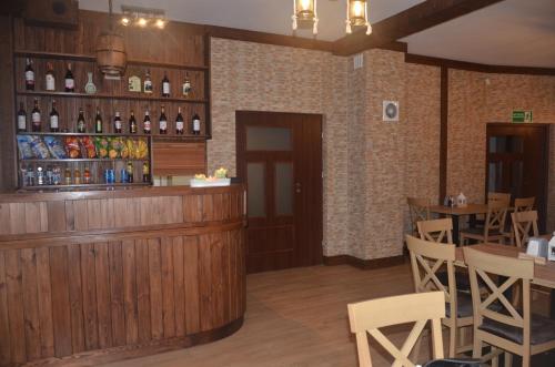 a restaurant with a bar and tables and wine bottles at Noclegi Avoca in Pyrzowice