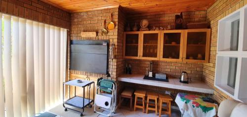 eine Küche mit einem TV sowie einem Tisch und Stühlen in der Unterkunft Hinterheim in Lambertʼs Bay