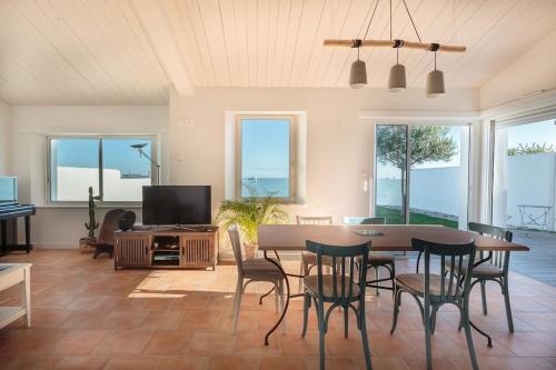 a living room with a table and chairs and a tv at Maison Vue mer panoramique in Rivedoux-Plage