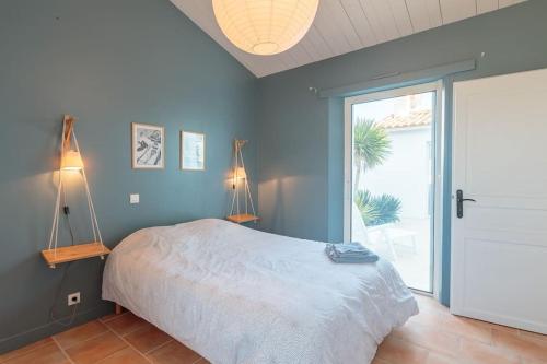 a bedroom with a bed and a large window at Maison Vue mer panoramique in Rivedoux-Plage