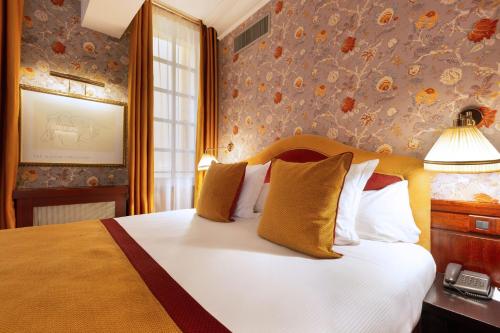 a bedroom with a large white bed with yellow pillows at Grand Hotel de l'Opera - BW Premier Collection in Toulouse