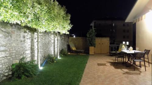a backyard at night with a table and chairs at MillyHolidays - Apartment Sunflower - Center - Nearby Beach - Private Garden - Spa Pool in Bardolino