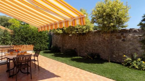 a patio with a table and chairs under a yellow umbrella at MillyHolidays - Apartment Sunflower - Center - Nearby Beach - Private Garden - Spa Pool in Bardolino