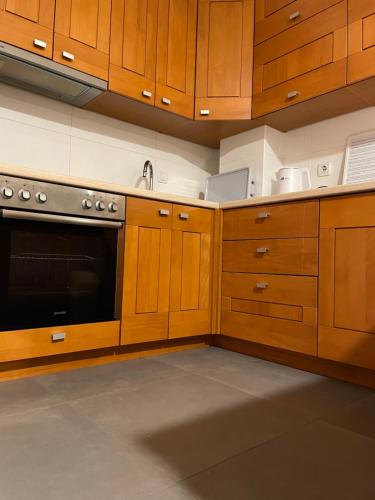 a kitchen with wooden cabinets and a stove at Apartman CITY CENTER 1-šetalište in Prijedor