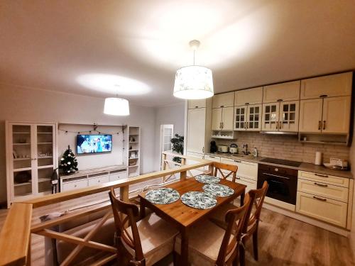 a kitchen with a table and chairs and a television at Sand Beach Apartment in Narva-Jõesuu