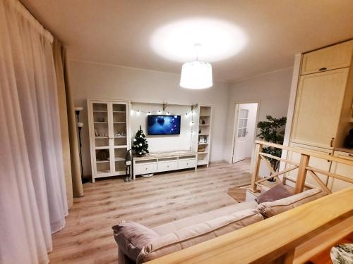Sand Beach Apartment في نارفا يويسو: غرفة معيشة مع أريكة وتلفزيون بشاشة مسطحة