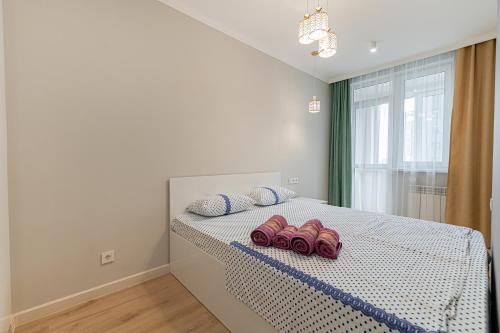 a bedroom with a bed with two pairs of shoes on it at Tau Tengry in Astana
