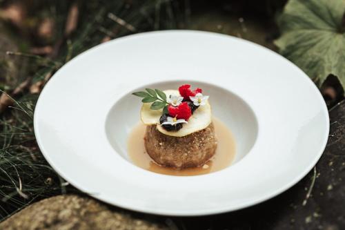 a white plate with a dessert on a table at Hotel Braunsbergerhof in Lana