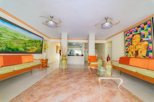 a living room with orange furniture and a large painting at Hotel Yonu in Punta Cana