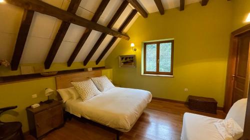 a bedroom with two beds in a room with yellow walls at La Borda del Tío Nicolás - Selva de Irati in Aribe