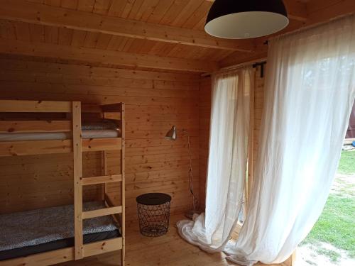 a room with two bunk beds and a window at Przystań Tło dla Mew in Rydzewo
