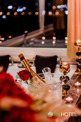 a table with wine bottles and glasses on it at Hotel Bonsai in Tirana