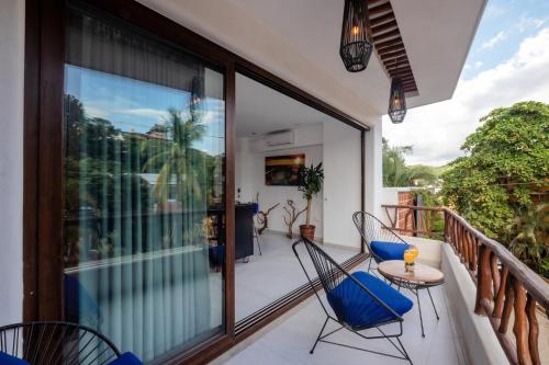 a balcony with chairs and a table at Casa Makawe ONLY ADULTS in Sayulita