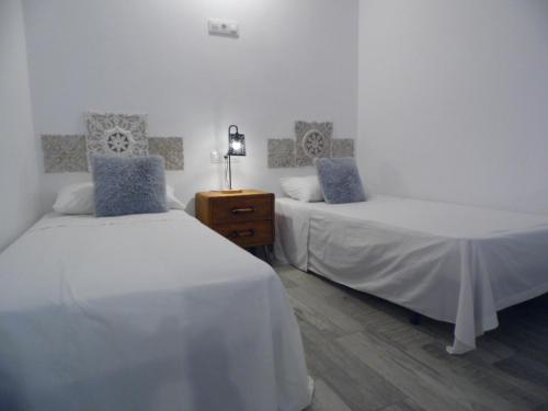 a bedroom with two beds and a dresser with a lamp at Puerto Marina in Benalmádena