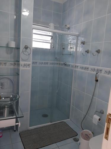 La salle de bains est pourvue d'une douche avec une porte en verre. dans l'établissement Apto 1 dorm Guarujá, Enseada, 1 quadra da praia, à Guarujá