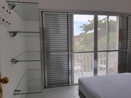 - une chambre avec un lit et une fenêtre avec vue dans l'établissement Apto 1 dorm Guarujá, Enseada, 1 quadra da praia, à Guarujá