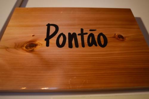 a wooden sign with the word ponato on it at Largo Bispo Boutique Hostel in Horta