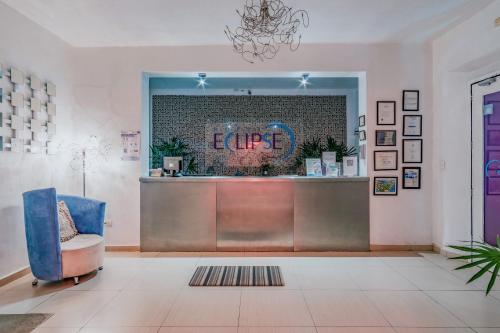 梅里達的住宿－Hotel Eclipse Mérida，一个带柜台和蓝椅的商店大堂
