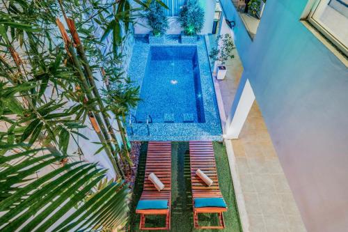 梅里達的住宿－Hotel Eclipse Mérida，享有带躺椅的游泳池的顶部景致