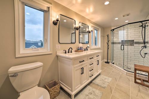 a bathroom with a toilet and a sink and a shower at Chic Manistee Cottage Steps to Lake Michigan! in Manistee