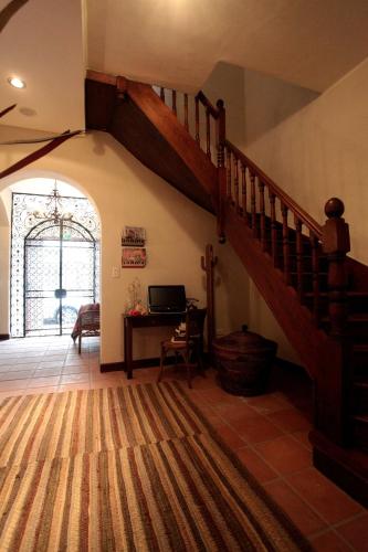a hallway with a staircase in a house with a desk at Hotel Boutique Balcón de la Plaza in Salta
