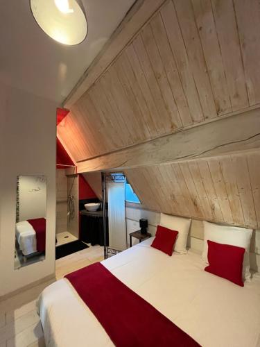 une chambre avec un grand lit blanc avec des oreillers rouges dans l'établissement Appartement 1 chambre Lili, à Poligny