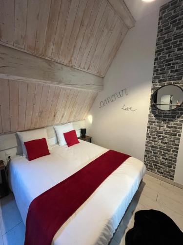une chambre avec un grand lit blanc avec des oreillers rouges dans l'établissement Appartement 1 chambre Lili, à Poligny