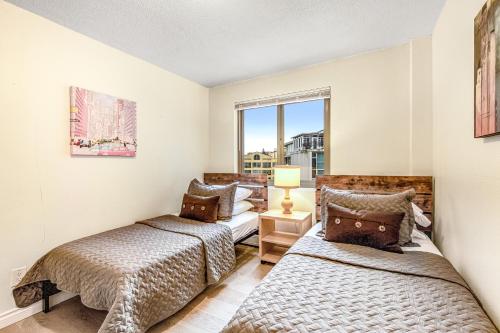 2 camas en una habitación con ventana en Hubble Place Condos en Seattle