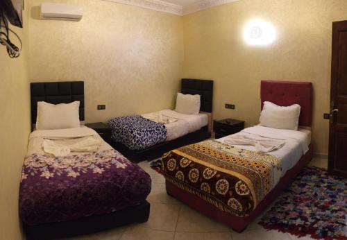 a room with two beds in a room at Riad Rayan's Guests in Marrakesh