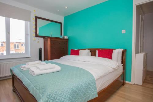 um quarto com uma cama grande e toalhas em Stunning 3 Bedroom House with Garden in Battersea em Londres